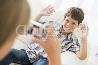 Young girl taking picture of smiling young boy with camera phone