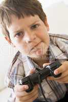 Young boy holding video game controller looking confused