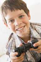 Young boy holding video game controller smiling