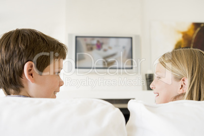Young boy and young girl in living room with flat screen televis