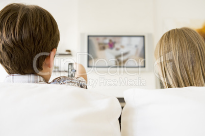 Young boy and young girl in living room with remote control and