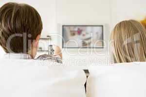 Young boy and young girl in living room with remote control and