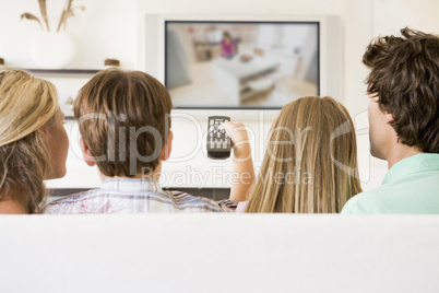 Family in living room with remote control and flat screen televi