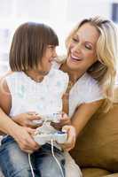 Woman and young girl in living room with video game controllers