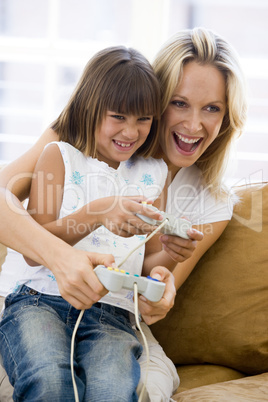 Woman and young girl in living room with video game controllers