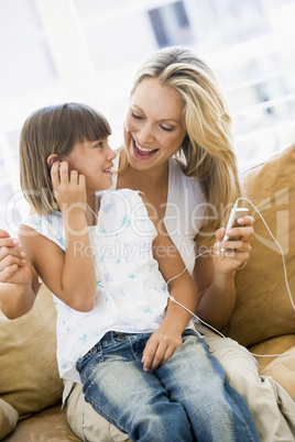 Woman and young girl in living room with MP3 player smiling