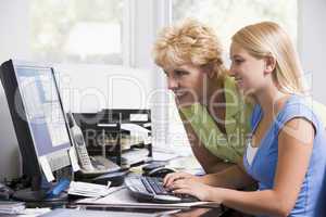 Woman and girl in home office with computer smiling