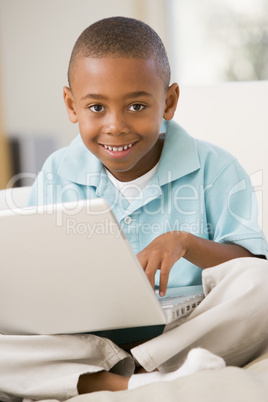 Young boy in living room with laptop smiling