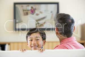 Man and young boy in living room with flat screen television smi