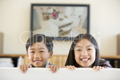 Two young children in living room with flat screen television sm