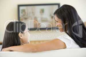 Woman and young girl in living room with flat screen television