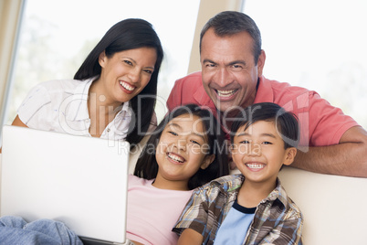 Family in living room with laptop smiling