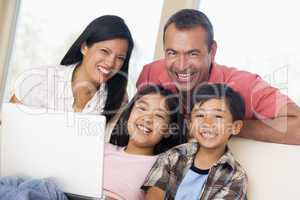 Family in living room with laptop smiling