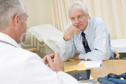 Man in doctor's office frowning