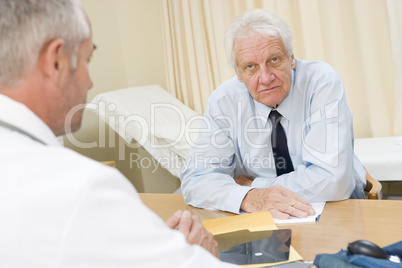 Man in doctor's office frowning