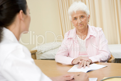 Woman in doctor's office frowning