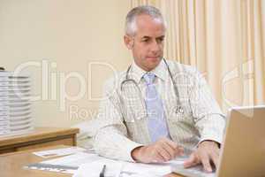 Doctor using laptop in doctor's office