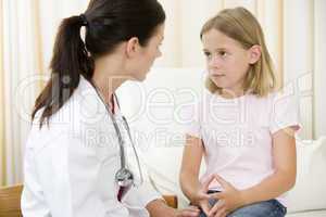 Doctor giving checkup to young girl in exam room