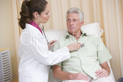 Doctor giving checkup with stethoscope to man in exam room