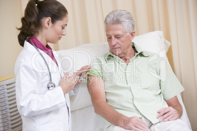 Doctor giving man needle in exam room