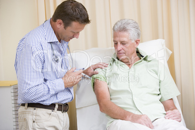 Doctor giving man needle in exam room