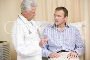 Doctor giving man checkup in exam room