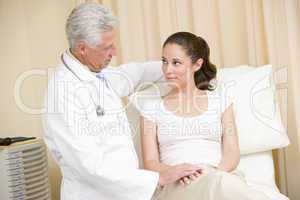 Doctor giving woman checkup in exam room