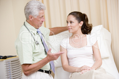 Doctor giving woman checkup in exam room