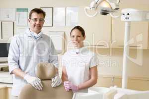 Dentist and assistant in exam room smiling