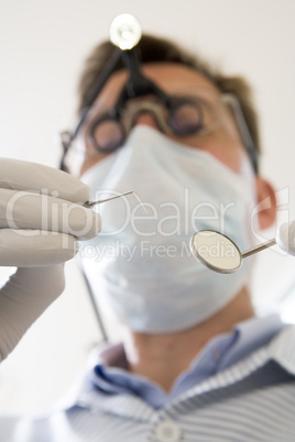 Dentist holding pick and mirror