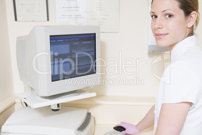 Dental assistant using computer smiling
