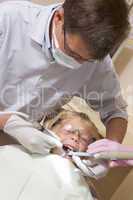 Dentist in exam room with young boy in chair