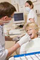 Dentist and assistant in exam room with young boy in chair