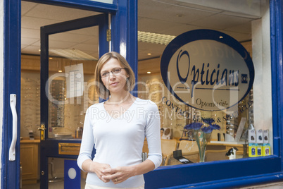 Woman standing at front entrance of optometrists