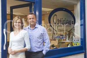 Couple standing at front entrance of optometrists smiling