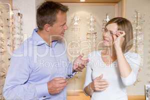 Couple trying on eyeglasses at optometrists