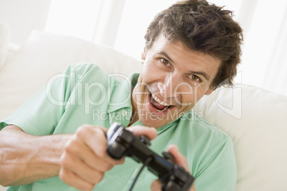 Man in living room playing videogames smiling