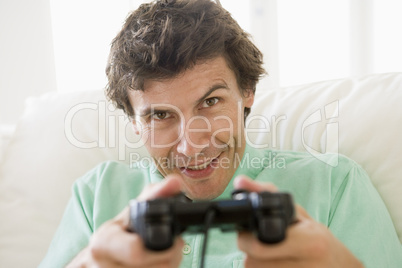 Man in living room playing videogames smiling