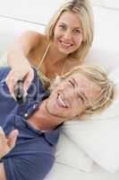 Couple in living room with remote control smiling
