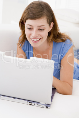 Woman in living room with laptop smiling