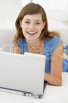 Woman in living room with laptop smiling