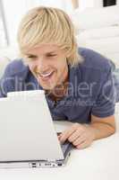 Man in living room with laptop smiling