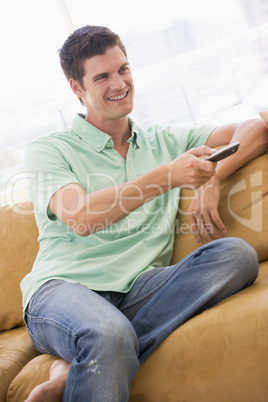 Man in living room with remote control smiling