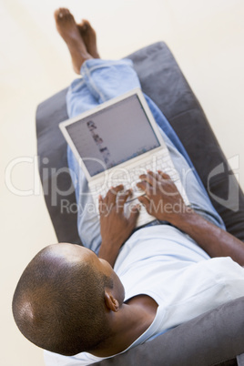 Man sitting in chair using laptop