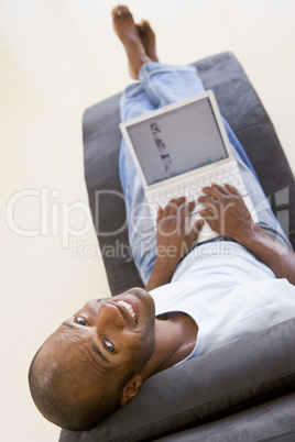 Man sitting in chair using laptop smiling