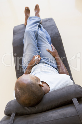 Man sitting in chair listening to MP3 player