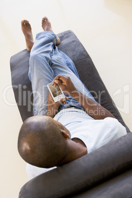 Man sitting in chair using personal digital assistant