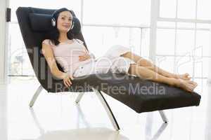 Woman sitting in chair wearing headphones smiling