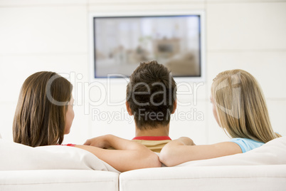 Three friends in living room watching television