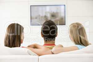 Three friends in living room watching television